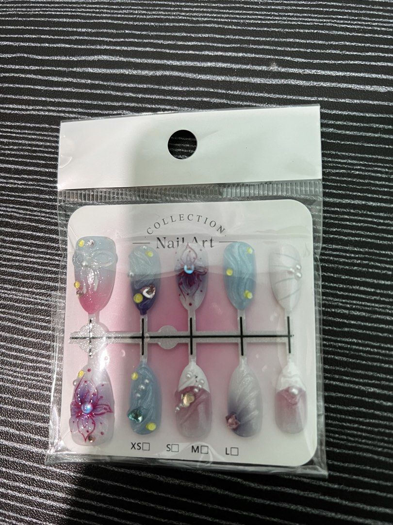 Nail Art Collection Press On Nails Set (Category: Hands & Nails) located in Consolacion. Submitted by hann_m_m (Listing ID 1464760761, Image 1). Description: - Brand new, unopened press-on nail set in original packaging. Sticky tab included. - Includes 10 decorated fake nail tips - Features colorful floral patterns, swirls, pearls, and rhinestones - Various sizes available from XS to L (printed on backing card) - Protected in a clear plastic oute