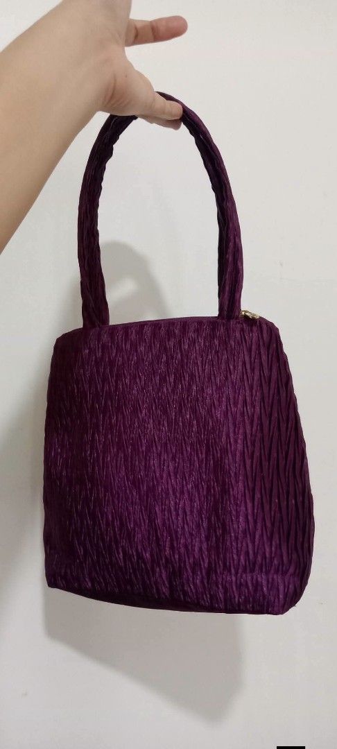 NaRaYa Handbag (Category: Tote Bags) located in Gapan. Submitted by montesnora80204 (Listing ID 1464706190, Image 2). Description: - Brand: NaRaYa - Color: Deep purple with a chic crinkled fabric texture - Straps: Comfortable dual shoulder straps - Closure: Top zipper with a branded pull tab - Interior: Clean white fabric lining featuring the NaRaYa logo - Size: Compact structured shape, ideal for daily essentials - Condition: Excellent / Pre-lov