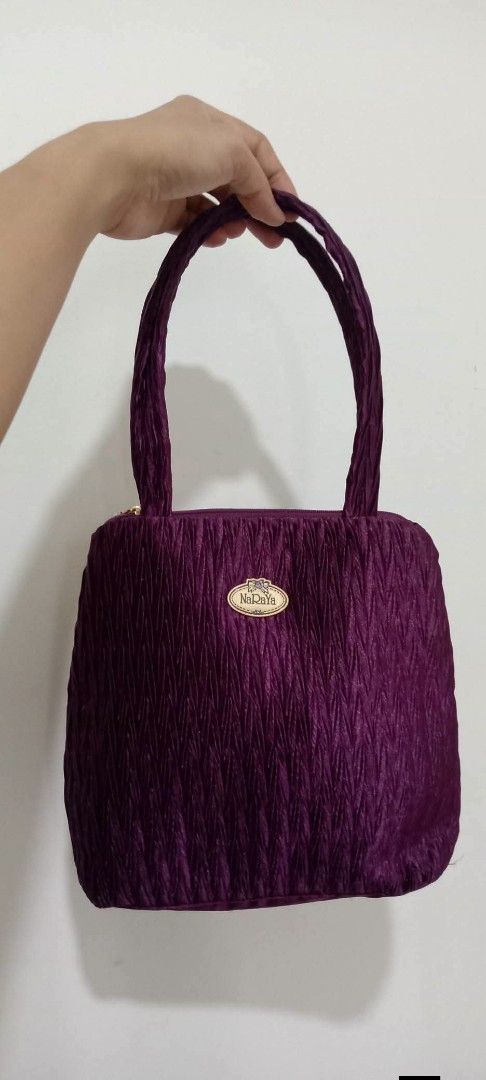 NaRaYa Handbag (Category: Tote Bags) located in Gapan. Submitted by montesnora80204 (Listing ID 1464706190, Image 1). Description: - Brand: NaRaYa - Color: Deep purple with a chic crinkled fabric texture - Straps: Comfortable dual shoulder straps - Closure: Top zipper with a branded pull tab - Interior: Clean white fabric lining featuring the NaRaYa logo - Size: Compact structured shape, ideal for daily essentials - Condition: Excellent / Pre-lov