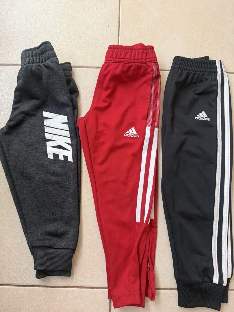 Nike & Adidas Track Pants Bundle (Category: Babies & Kids Fashion) located in Makati City. Submitted by etherealuxe.ph (Listing ID 1464625917, Image 1). Description: - Bundle of 3 track pants for 999 - Includes: 1 Grey Nike (large logo), 1 Red Adidas (3 stripes), 1 Black Adidas (3 stripes) - Features elastic waistbands - Ideal for sports and casual wear.