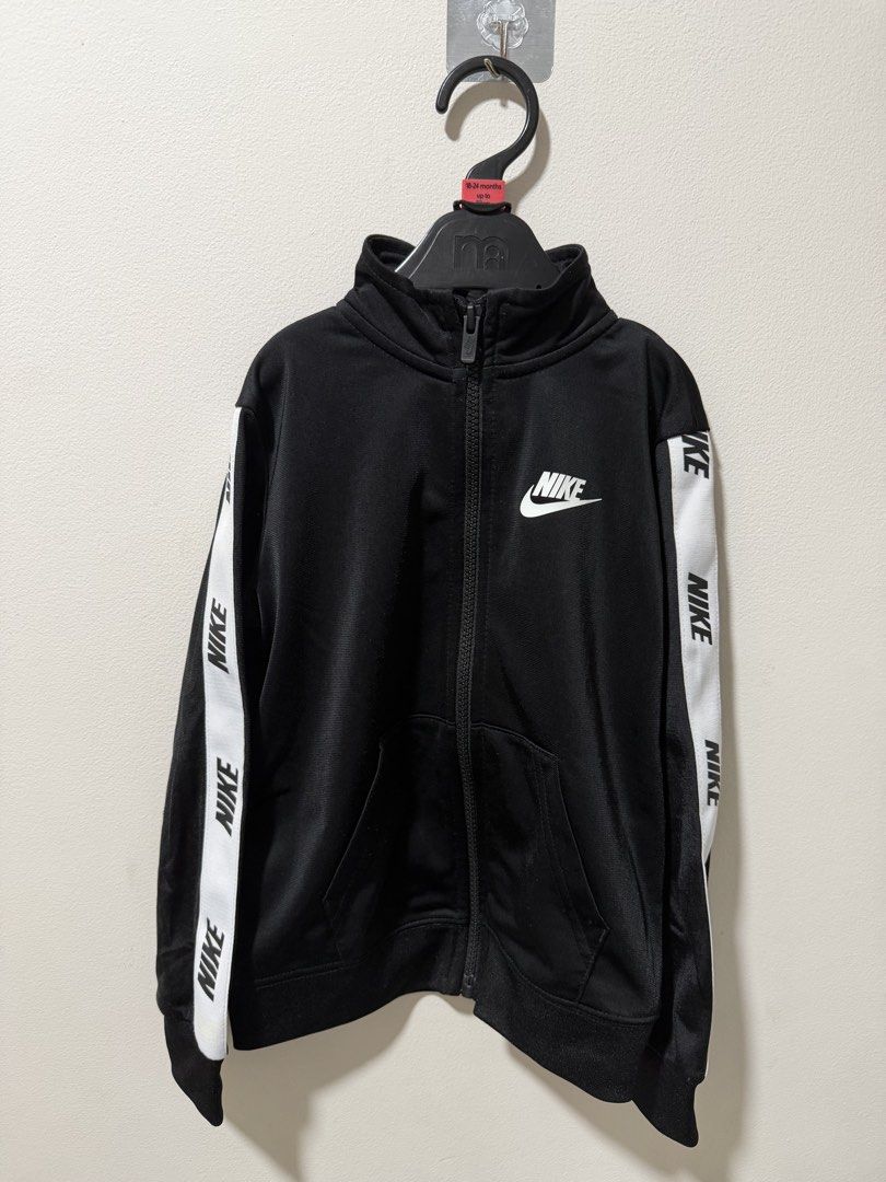 Nike Black White Tape Tracksuit Set (Category: Babies & Kids Fashion) located in Manila. Submitted by dejavogue.ph (Listing ID 1464644545, Image 2). Description: - Authentic Nike tracksuit set - Classic black with white Nike tape detail on sleeves and legs - Full zip jacket with convenient pockets - Comfortable pants with elastic waistband - Versatile for everyday wear or athletic activities.
