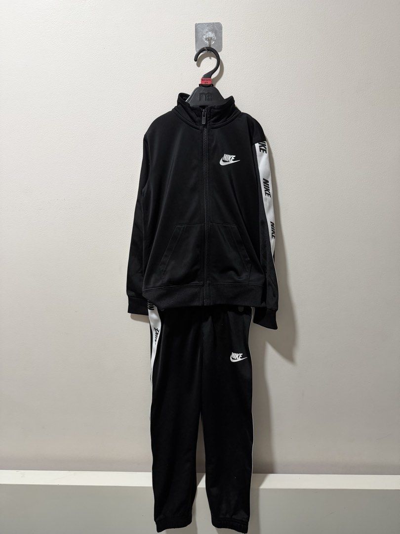 Nike Black White Tape Tracksuit Set (Category: Babies & Kids Fashion) located in Manila. Submitted by dejavogue.ph (Listing ID 1464644545, Image 1). Description: - Authentic Nike tracksuit set - Classic black with white Nike tape detail on sleeves and legs - Full zip jacket with convenient pockets - Comfortable pants with elastic waistband - Versatile for everyday wear or athletic activities.