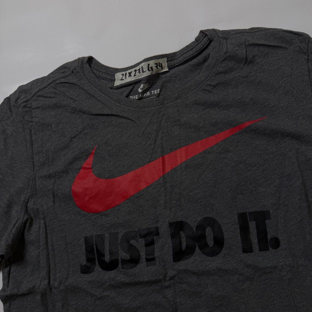 Nike Just Do It Grey T-Shirt Size L (Category: Tshirts & Polo Shirts ) located in Manila. Submitted by johnedel_james (Listing ID 1464697985, Image 2). Description: - Brand: Nike (The Nike Tee) - Size: Large - Color: Grey with red swoosh and black 'Just Do It' chest graphic - Material: 100% Cotton - Origin: Made in Egypt - Fit: Athletic cut - Condition: Excellent pre-loved condition (tagged inside collar).