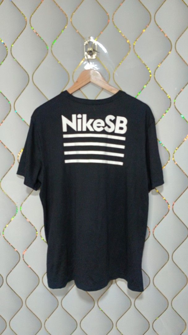 Nike SB The Nike Tee Black Graphic (Category: Tshirts & Polo Shirts ) located in Manila. Submitted by zariyah.1986 (Listing ID 1464756168, Image 2). Description: - Brand: Nike SB (The Nike Tee line) - Color: Black with white graphics - Material: Dri-FIT (moisture-wicking, athletic wear) - Size: XXL (Athletic cut fit) - Measurements: 23 inches across chest, 27 inches length - Design: Small front chest logo and large back graphic with horizontal li