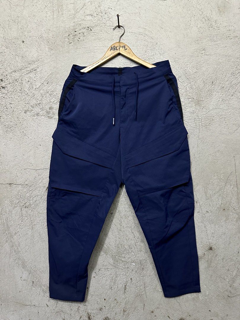 Nike Tech Fleece Cargo Pants Navy Blue (Category: Joggers) located in Quezon City. Submitted by stre3tw3ar (Listing ID 1464584403, Image 1). Description: - Navy blue Nike Tech Fleece cargo pants - Multiple pockets for storage - Convenient side zipper pocket - Adjustable drawstring waist - Ideal for everyday wear or training - Medium On tag - 32 On tape - 37 Length - 6 Hem.