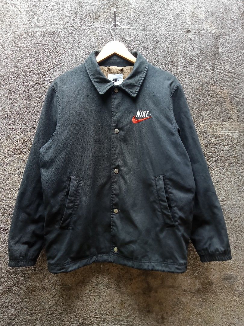 Nike Therma-Fit Coach Jacket (Category: Coats, Jackets and Outerwear) located in Sipocot. Submitted by danthrift122218 (Listing ID 1464622850, Image 1). Description: - Black Nike coach jacket - Features Therma-Fit technology for warmth - Large embroidered Nike swoosh on back - Smaller embroidered swoosh on chest - Quilted lining for extra insulation - Snap button closure - Ideal for cooler weather.