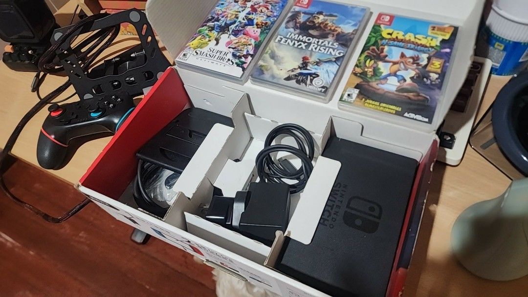 Nintendo Switch Console with Games and Accessories (Category: Nintendo) located in Marikina City. Submitted by tepmanalo (Listing ID 1464578737, Image 3). Description: - Complete Nintendo Switch console set - Includes dock, red & blue Joy-Cons, and all cables - Comes with Super Smash Bros. Ultimate, Immortals Fenyx Rising, and Crash Bandicoot N. Sane Trilogy - Extra controller included for multiplayer - All items are in their original packaging -