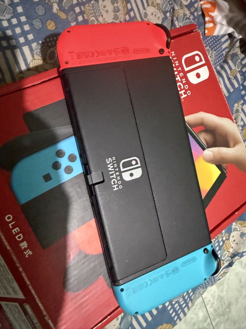 Nintendo Switch OLED Model Console with Neon Red/Blue Joy-Cons (Category: Nintendo) located in Manila. Submitted by jrroque (Listing ID 1464674626, Image 2). Description: - Nintendo Switch OLED Model - Neon Red and Blue Joy-Cons included - Comes with dock and all necessary cables - Original box included - Ready for gaming at home or on the go - Feel free to ask any questions! - comes with two games nba and super mario deluxe - comes with 128 gb m