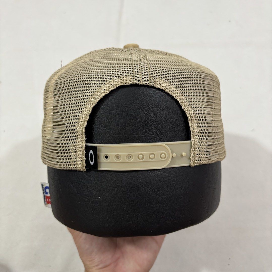 Oakley Established 1975 Trucker Hat Tan (Category: Caps & Hats) located in Cavite. Submitted by itsayaaa (Listing ID 1464698995, Image 3). Description: - Brand: Oakley - Color: Tan - Design: Diamond patch logo with 'Oakley Established 1975' in black and white - Material: Breathable mesh back panels - Brim: Curved with tonal stitching - Closure: Adjustable snapback - Condition: Clean piece, ready to wear.
