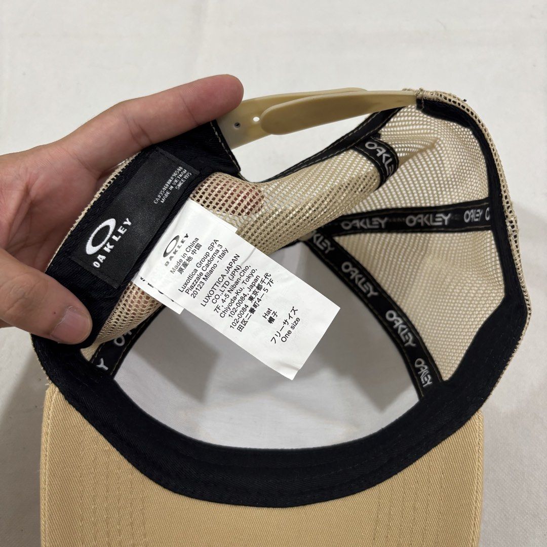 Oakley Established 1975 Trucker Hat Tan (Category: Caps & Hats) located in Cavite. Submitted by itsayaaa (Listing ID 1464698995, Image 2). Description: - Brand: Oakley - Color: Tan - Design: Diamond patch logo with 'Oakley Established 1975' in black and white - Material: Breathable mesh back panels - Brim: Curved with tonal stitching - Closure: Adjustable snapback - Condition: Clean piece, ready to wear.