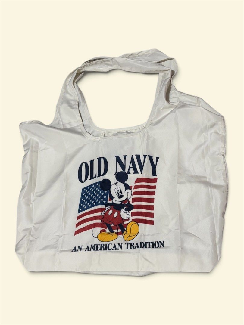 Old Navy x Disney Mickey Mouse Packable Tote (Category: Tote Bags) located in Pasig City. Submitted by burtonxxx (Listing ID 1464690640, Image 2). Description: - Brand new with original store tags attached - Authentic Old Navy and Disney collaboration - Cream background with Mickey Mouse and American flag graphic - Made of lightweight 100% polyester material - Packs down compactly into its own attached pouch for easy storage - Dimensions: 16x21.