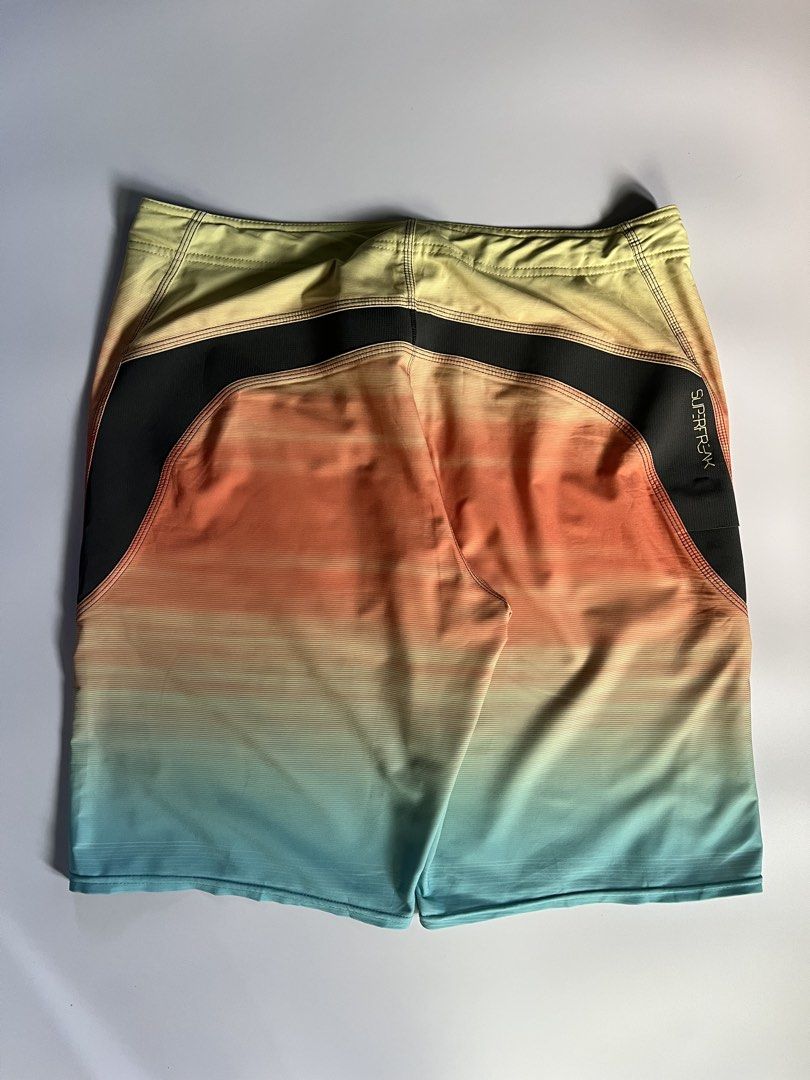O'Neill Superfreak Gradient Board Shorts Size 33 (Category: Swim Trunks & Board Shorts) located in Baler. Submitted by allthrifted31 (Listing ID 1464732015, Image 2). Description: - Brand: O'Neill Superfreak - Style: Gradient board shorts (Yellow, orange, and blue) - Size: Tagged Size 33 - Waist: Adjustable black drawstring closure - Design: Contrasting dark side panels with iconic O'Neill and Superfreak branding - Material: Lightweight, quick-dr