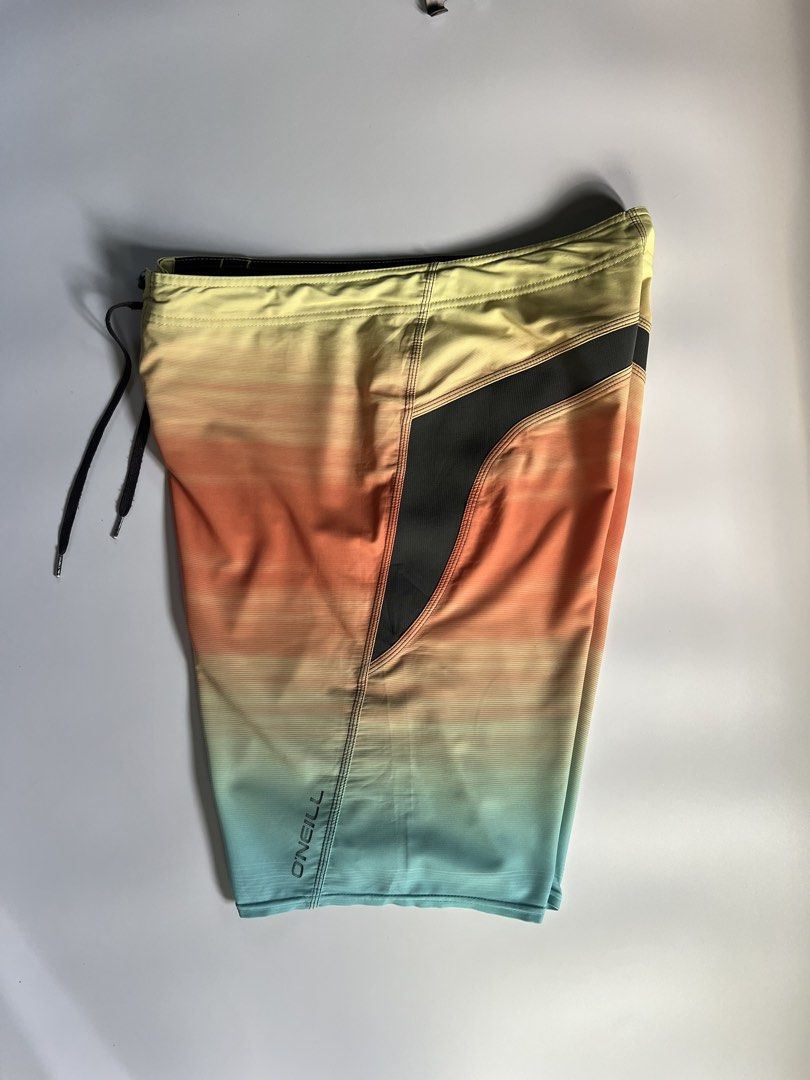 O'Neill Superfreak Gradient Board Shorts Size 33 (Category: Swim Trunks & Board Shorts) located in Baler. Submitted by allthrifted31 (Listing ID 1464732015, Image 3). Description: - Brand: O'Neill Superfreak - Style: Gradient board shorts (Yellow, orange, and blue) - Size: Tagged Size 33 - Waist: Adjustable black drawstring closure - Design: Contrasting dark side panels with iconic O'Neill and Superfreak branding - Material: Lightweight, quick-dr