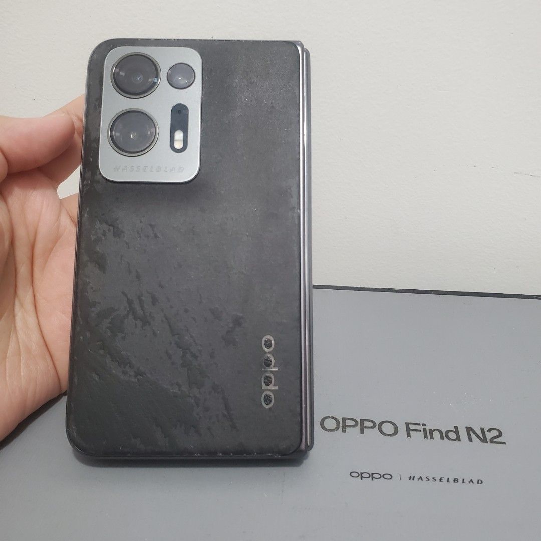 Oppo Find N2 Fold (Category: OPPO) located in Baguio. Submitted by virtualgarage.sale (Listing ID 1461897533, Image 3). Description: please read!!! oppo find n2 fold black vegan leather already peeled off but put matte acrylic finisher on the back for protection see photos for 'about phone' details excellent working condition no functional issues no repair history has cosmetic flaws and signs of use (please see photos for details) comes with box 