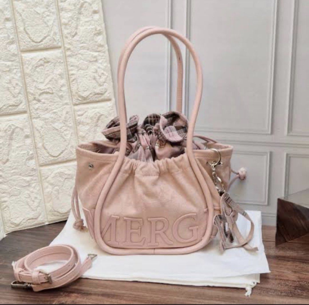 Original Merge Bag (Category: Tote Bags) located in Manila. Submitted by vengonflo (Listing ID 1464726797, Image 2). Description: - A popular brand in Thailand. - Stylish denim tote bag with pink leather trim and straps - Features large embossed 'SUPER SUN MERG' lettering on the front - Drawstring cinched top with a trendy plaid inner lining - Equipped with dual shoulder handles and a detachable crossbody strap - Comes with a cute, matching brand