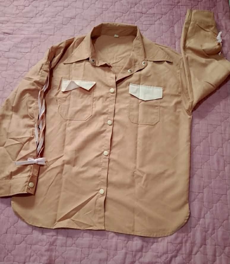 Peach Button-Up Shirt with White Pocket Details (Category: Shirts) located in Barobo. Submitted by angeljanet29035 (Listing ID 1464648933, Image 1). Description: - Classic peach button-up shirt - Two white pocket details on the chest - Long sleeves with ribbon detail on the cuffs - Simple and versatile style - Ideal for casual outfits.