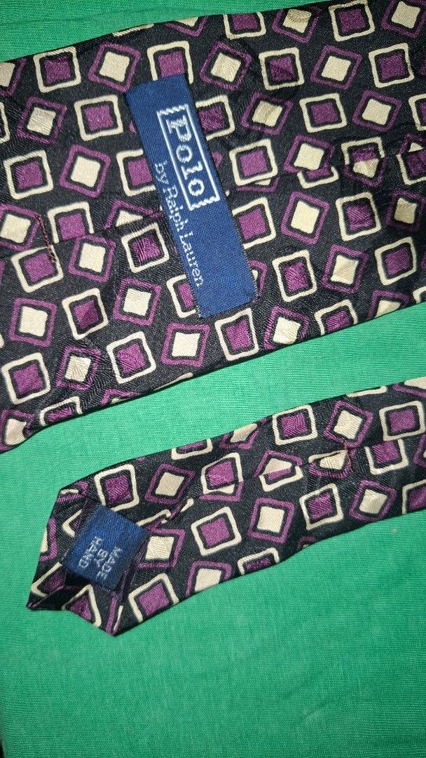Polo by Ralph Lauren Silk Tie - Geometric Pattern (Category: Ties) located in Coron. Submitted by sirizchoice (Listing ID 1464578800, Image 2). Description: - Classic Polo by Ralph Lauren tie - Features a cool geometric pattern with purple and cream squares on a dark background - Made of 100% silk - Perfect for dressing up any outfit - A stylish addition to any tie collection.