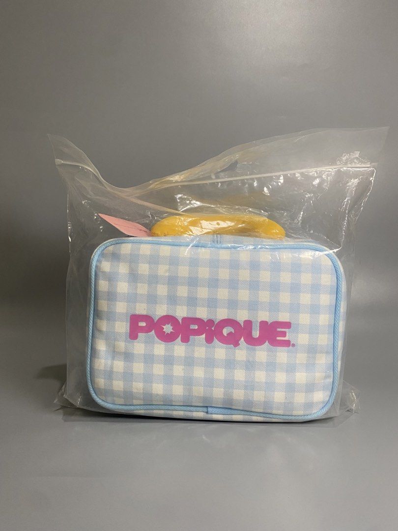 Popique Blue Gingham Hanging Toiletry Bag (Category: Purses & Pouches) located in Davao. Submitted by brandedthrift.134 (Listing ID 1464735711, Image 3). Description: - Brand: Popique - Condition: Brand new with tags in original plastic zip bag - Design: Blue and white gingham pattern with pink branding logo and bright yellow top handle - Features: Built-in hanging hook and multiple zippered compartments with clear plastic lining.