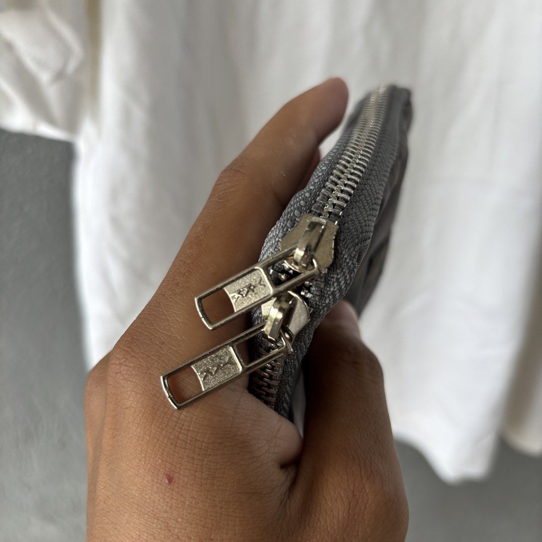 Porter wallet (Category: Belt bags, Clutches and Pouches) located in San Fernando. Submitted by diff.thr1ft (Listing ID 1464584838, Image 2). Description: - Authentic Porter wallet - Color: Gray - Material: Durable nylon - Features multiple compartments for organization - Smooth zipper closure.