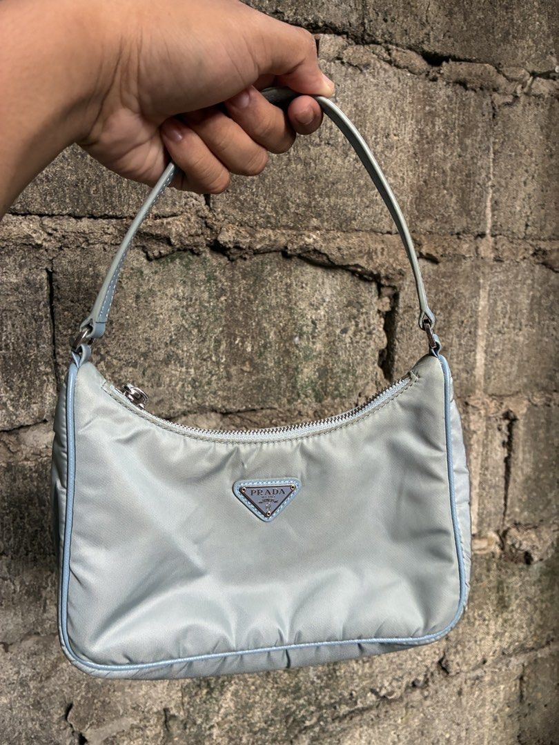 Prada Nylon Mini Hobo Bag Light Blue (Category: Luxury Bags & Wallets) located in Manila. Submitted by assortedgoodsv3 (Listing ID 1464764626, Image 2). Description: - Authentic Prada nylon shoulder bag in a rare light blue shade - Classic curved silhouette with silver-toned hardware - Iconic enamel triangle logo plate on the front - Secure top zip closure with branded zipper pull - Clean interior lined with signature Prada jacquard fabric - Incl