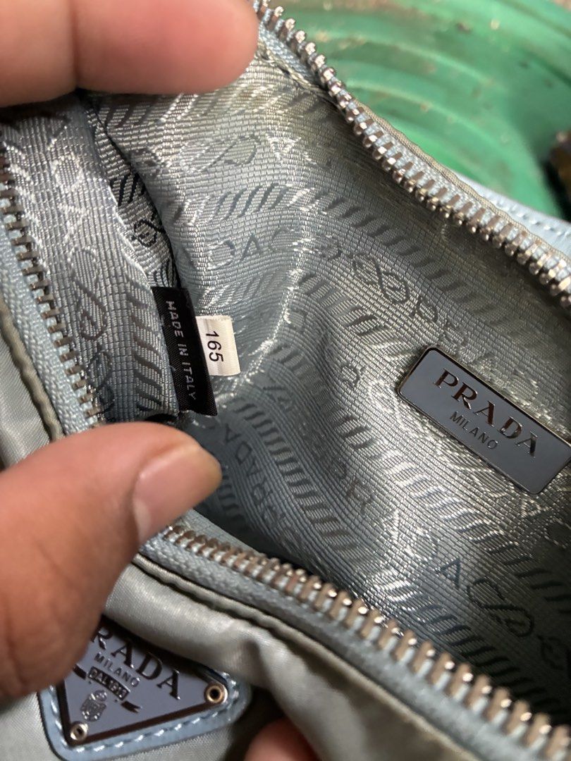 Prada Nylon Mini Hobo Bag Light Blue (Category: Luxury Bags & Wallets) located in Manila. Submitted by assortedgoodsv3 (Listing ID 1464764626, Image 3). Description: - Authentic Prada nylon shoulder bag in a rare light blue shade - Classic curved silhouette with silver-toned hardware - Iconic enamel triangle logo plate on the front - Secure top zip closure with branded zipper pull - Clean interior lined with signature Prada jacquard fabric - Incl