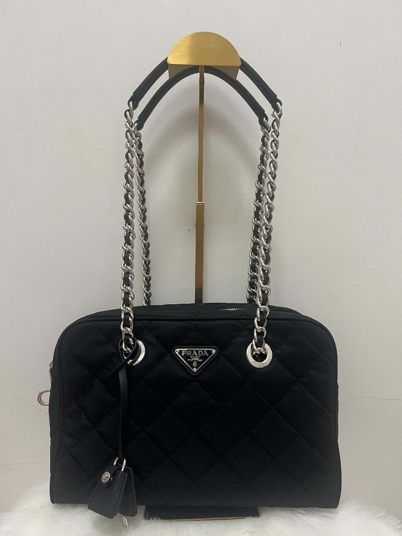 Prada Quilted Nylon Chain Shoulder Bag Black (Category: Luxury Bags & Wallets) located in Paoay. Submitted by rvf1230 (Listing ID 1464603102, Image 2). Description: - Authentic Black Prada Shoulder Bag - Quilted Nylon Material - Silver Chain Straps - Iconic Prada Triangle Logo - Includes Small Leather Tag Accessory - Versatile: Great for Everyday or Special Occasions - Condition: Clean and Well-Maintained.