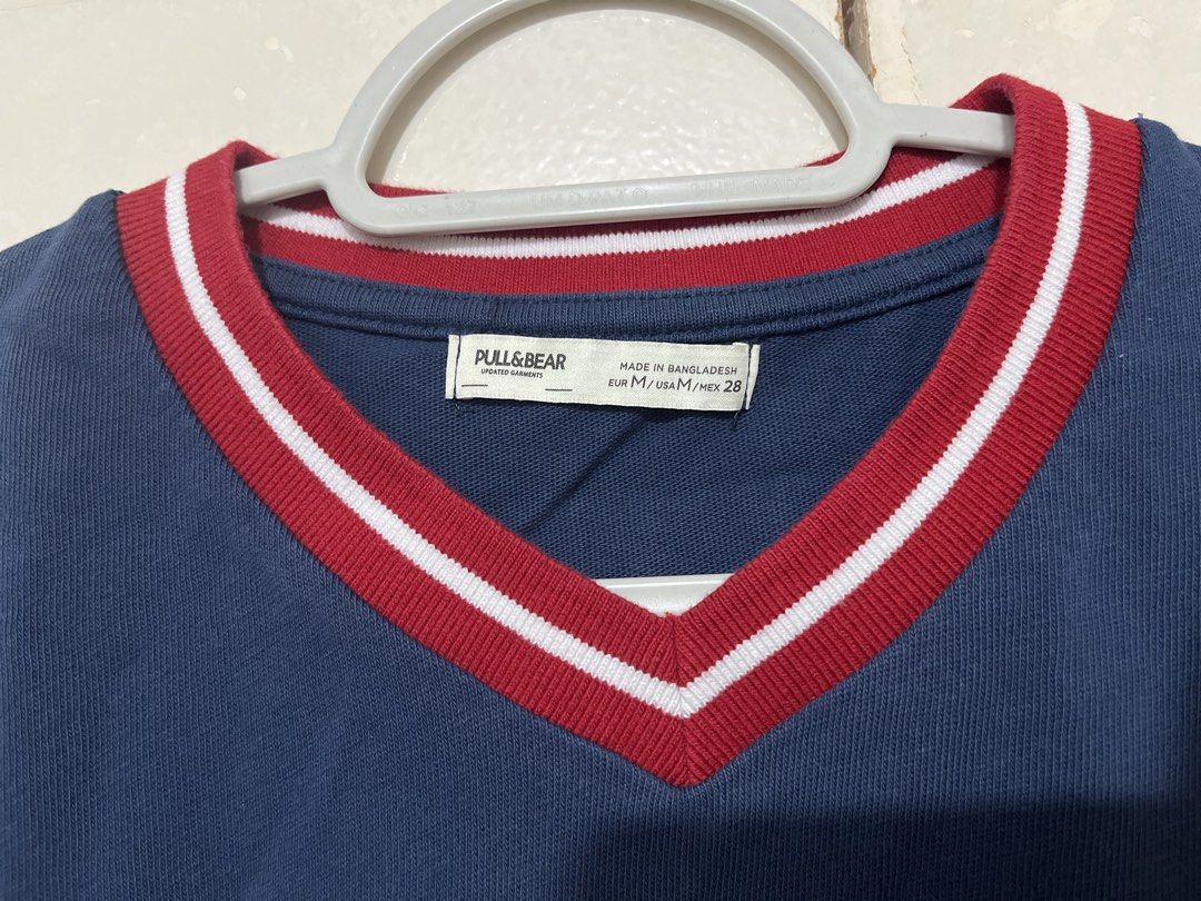 Pull & Bear Navy Blue Manhattan Midtown Cropped T-shirt (Category: Shirts) located in Paranaque City. Submitted by iya.dcltr (Listing ID 1464589620, Image 2). Description: - Navy blue cropped t-shirt - Brand: Pull & Bear - V-neck with red and white trim - Front graphic: 'Manhattan Midtown Diamond District' - Short sleeves with matching trim - Perfect for a casual, sporty look - Pairs well with jeans or shorts.