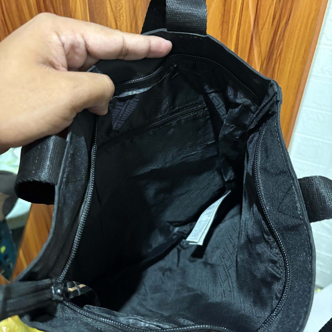Puma Black Tote Bag with Gold Logo (Category: Tote Bags) located in Carmen. Submitted by ar_thrift00 (Listing ID 1464713112, Image 3). Description: Black Puma tote bag sporting a gold logo on the front. Double carrying handles made of sturdy webbing. Zipper closure across the top to keep your items secure. Inside lining features Puma branding pattern with an extra zippered pocket for smaller essentials. Generous space for daily errands, gym gear,