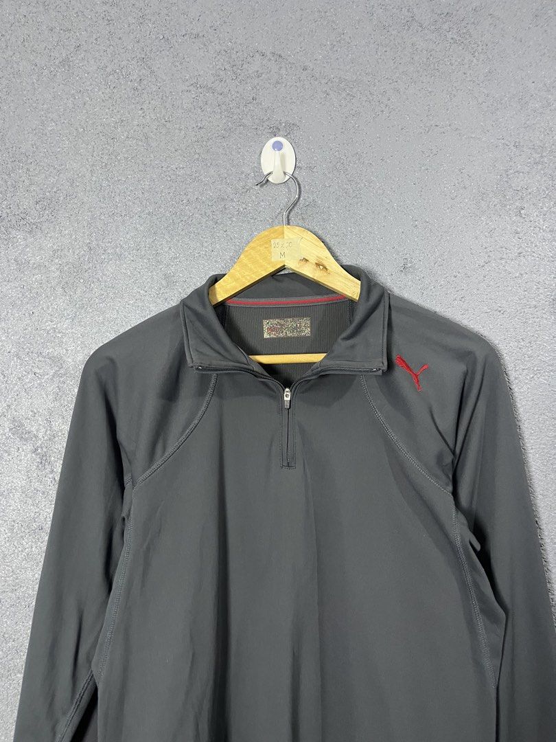 Puma Dark Grey Half Zip Pullover Size M (Category: Coats, Jackets and Outerwear) located in Famy. Submitted by basicthrifted (Listing ID 1464704106, Image 2). Description: - Brand: Puma - Style: Half-zip pullover with long sleeves - Color: Dark grey with red accents - Logo: Red embroidered Puma logo on left chest - Details: Ribbed collar with thin red accent line, Made in Japan inner tag - Size: M (approx. 25" length by 20" width) - Condition/Use