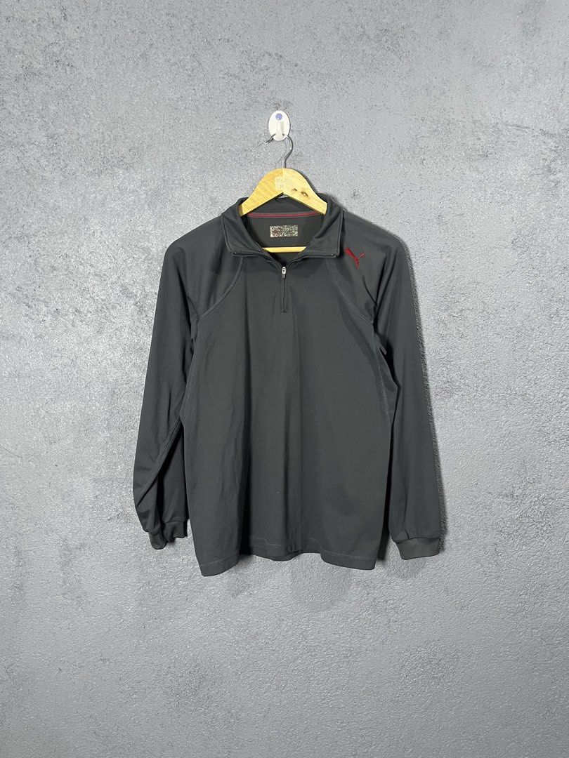 Puma Dark Grey Half Zip Pullover Size M (Category: Coats, Jackets and Outerwear) located in Famy. Submitted by basicthrifted (Listing ID 1464704106, Image 1). Description: - Brand: Puma - Style: Half-zip pullover with long sleeves - Color: Dark grey with red accents - Logo: Red embroidered Puma logo on left chest - Details: Ribbed collar with thin red accent line, Made in Japan inner tag - Size: M (approx. 25" length by 20" width) - Condition/Use