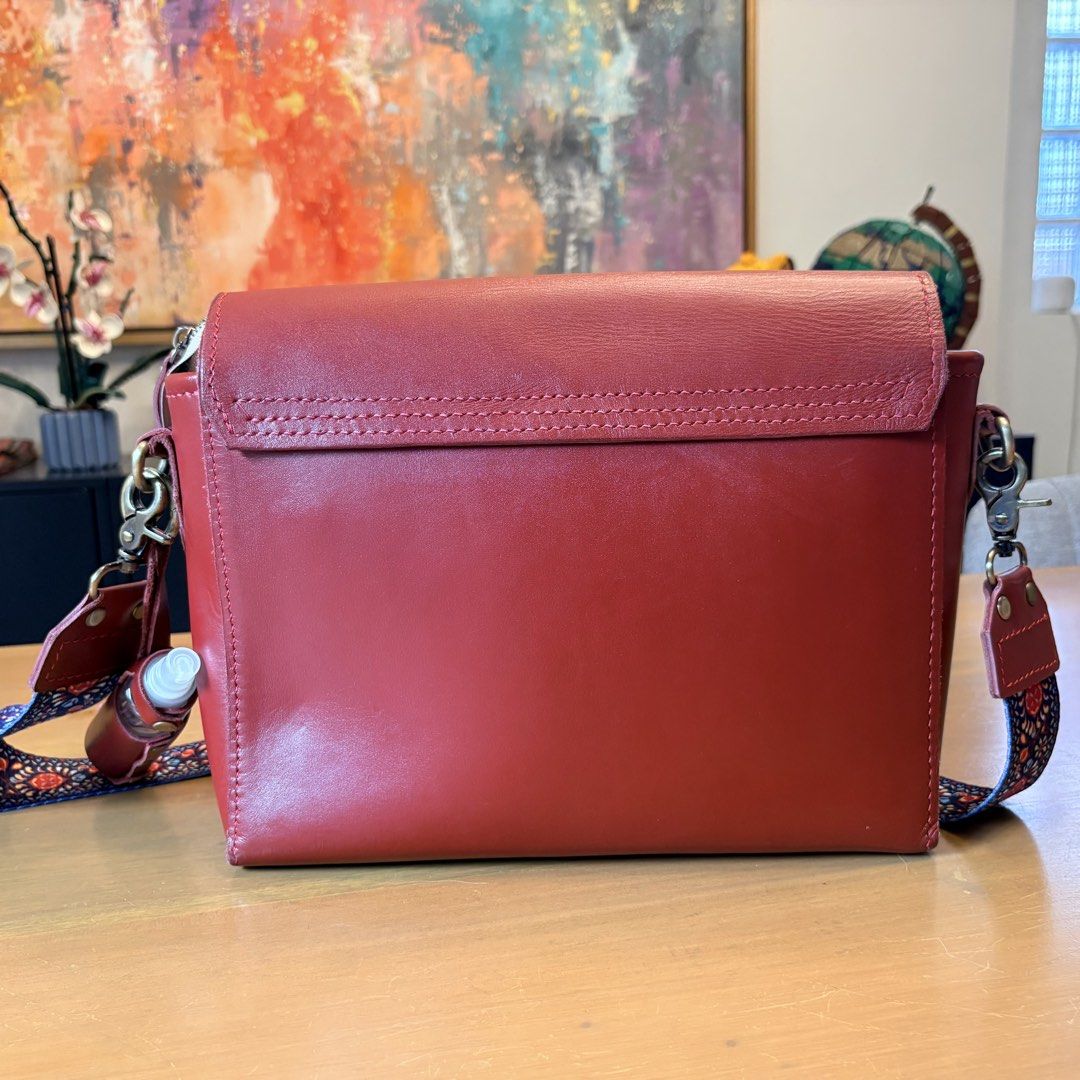 Red Leather Crossbody Bag with Patterned Strap (Category: Cross-body Bags) located in Pasig City. Submitted by bituin18 (Listing ID 1464575094, Image 2). Description: - Stylish red leather crossbody bag - Secure front clasp closure - Detachable patterned strap included - Convenient side bottle holder - Ideal for everyday wear - Approximately 11 inches wide.