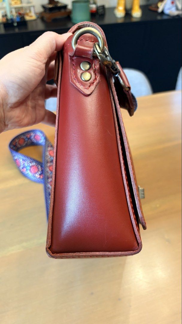 Red Leather Crossbody Bag with Patterned Strap (Category: Cross-body Bags) located in Pasig City. Submitted by bituin18 (Listing ID 1464575094, Image 3). Description: - Stylish red leather crossbody bag - Secure front clasp closure - Detachable patterned strap included - Convenient side bottle holder - Ideal for everyday wear - Approximately 11 inches wide.
