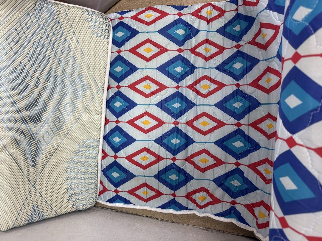 Reversible fold-out mattress pad with geometric diamond pattern (Category: Bedding & Towels) located in Pasig City. Submitted by cvj25 (Listing ID 1464700455, Image 1). Description: - Dual-sided design: Stylish blue/red geometric pattern on one side, cool blue/beige woven mat on the reverse - Versatile use: Ideal spare bed for guests, floor mat for kids' rooms, or lounging pad - Space-saving: Folds away easily for quick and convenient storage - D