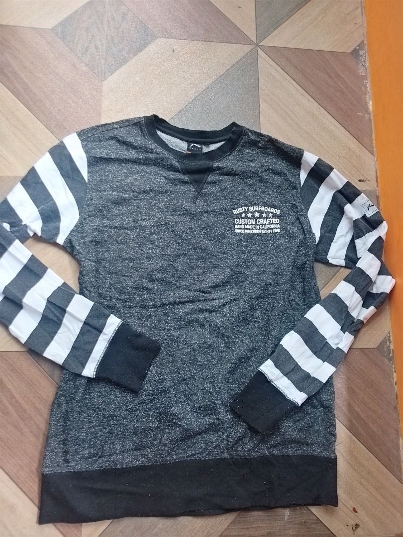 Rusty Surfboards Custom Crafted Crewneck Sweatshirt (Category: Coats, Jackets and Outerwear) located in Caloocan City. Submitted by hmm_shop83 (Listing ID 1464631953, Image 1). Description: - Brand: Rusty Surfboards - Type: Crewneck Sweatshirt - Color: Grey Marl - Size: M - Features: Graphic print on front and back ('Rusty Surfboards Custom Crafted Hand Made In California Since Nineteen Eighty Five'), striped sleeves (grey and white) - Style: Cas