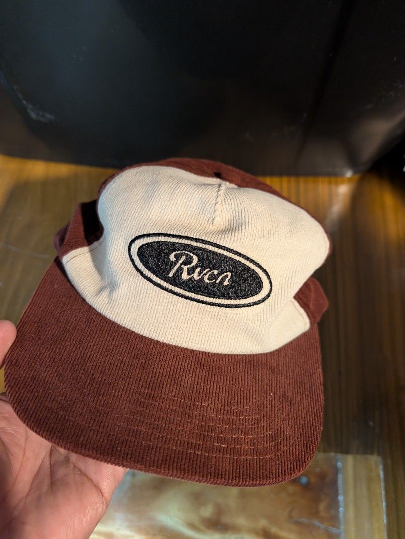 RVCA Badge Snapback (Good as new) (Category: Caps & Hats) located in Naga. Submitted by kenshin78 (Listing ID 1464729776, Image 1). Description: - Brand: RVCA - Material: Brown and white corduroy fabric - Design: Structured crown, flat brim, and oval embroidered logo patch on the front - Closure: Adjustable plastic snapback with a small logo tab - Condition: good as new / Excellent quality - Perfect for daily streetwear and casual outfits.