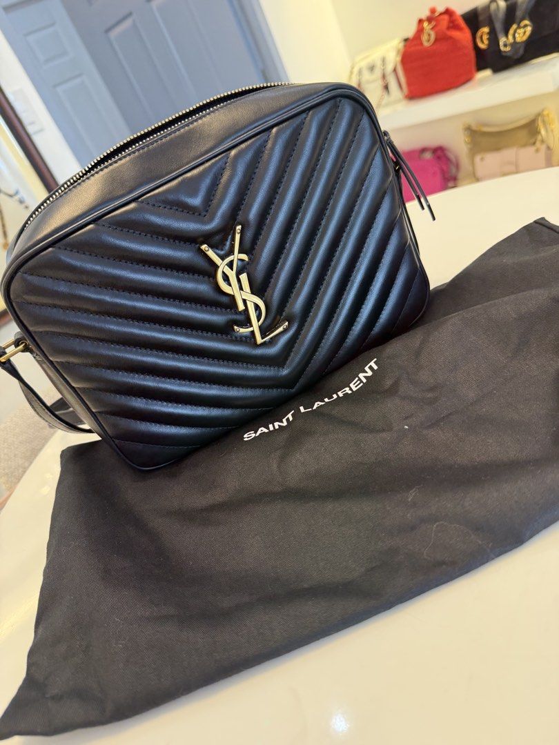 Saint Laurent Lou Camera Bag Black Gold Hardware (Category: Luxury Bags & Wallets) located in Alfonso. Submitted by luxurose (Listing ID 1464759934, Image 1). Description: - Brand: Saint Laurent (YSL) - Material: Black chevron quilted leather - Hardware: Iconic gold YSL monogram - Closure: Secure zip top - Interior: Fabric lining with a convenient slip pocket - Inclusions: Comes with matching black dust bag and box - Condition: Excellent, great f
