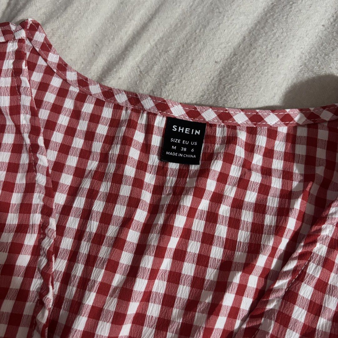 SHEIN Red Gingham Smocked Tie Front Top Size M (Category: Blouses) located in Cainta. Submitted by kairus.luckyfind (Listing ID 1464643997, Image 2). Description: NEVER USED - Cute red and white gingham top - Brand: SHEIN - Features: Tie front detail, smocked waist, short sleeves - Style: Casual, easy to wear - Pairs well with: Jeans or shorts.