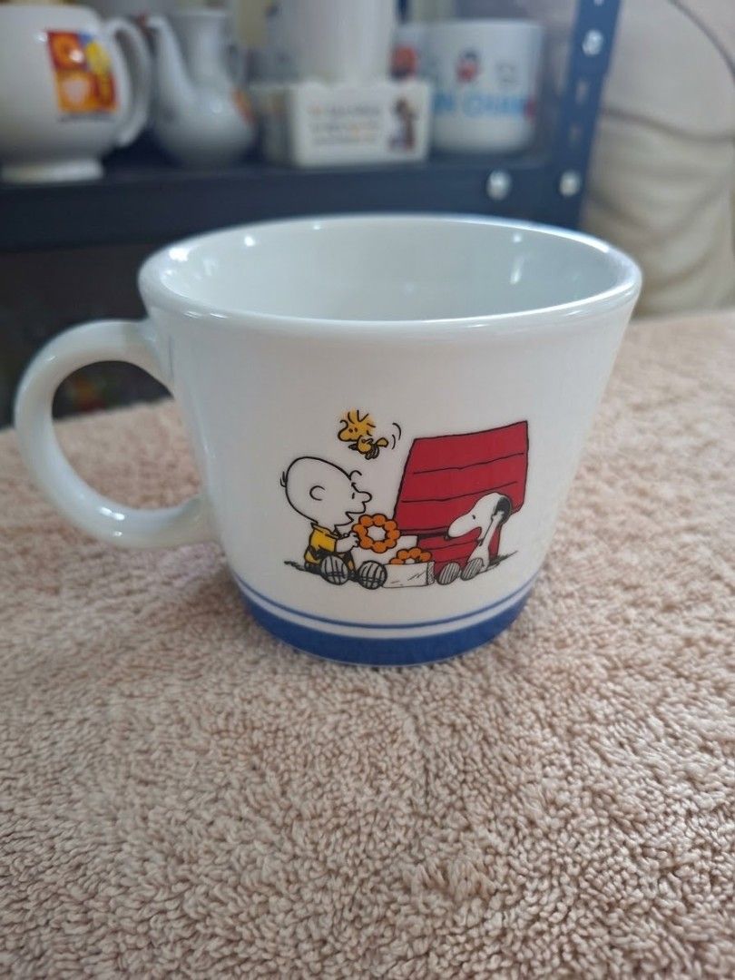 Snoopy Mug (Category: Coffee & Tea Tableware) located in Consolacion. Submitted by luxekerei (Listing ID 1464769102, Image 1). Description: - to be a 2016 Snoopy Christmas mug released as a promotional item by Mister Donut in Japan, featuring an illustration of Charlie Brown handing a gift to Snoopy on his red doghouse with Woodstock overhead, accented by a blue stripe along the base..