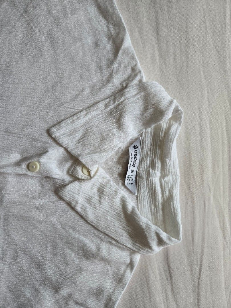 Stradivarius White Textured Button-Up Shirt (Category: Shirts) located in Quezon City. Submitted by mgdeclutters (Listing ID 1464599774, Image 2). Description: - Brand: Stradivarius - Color: White - Fabric: Textured - Style: Button-up shirt with collar - Features: Two chest pockets - Size: L - Occasion: Casual wear or layering.