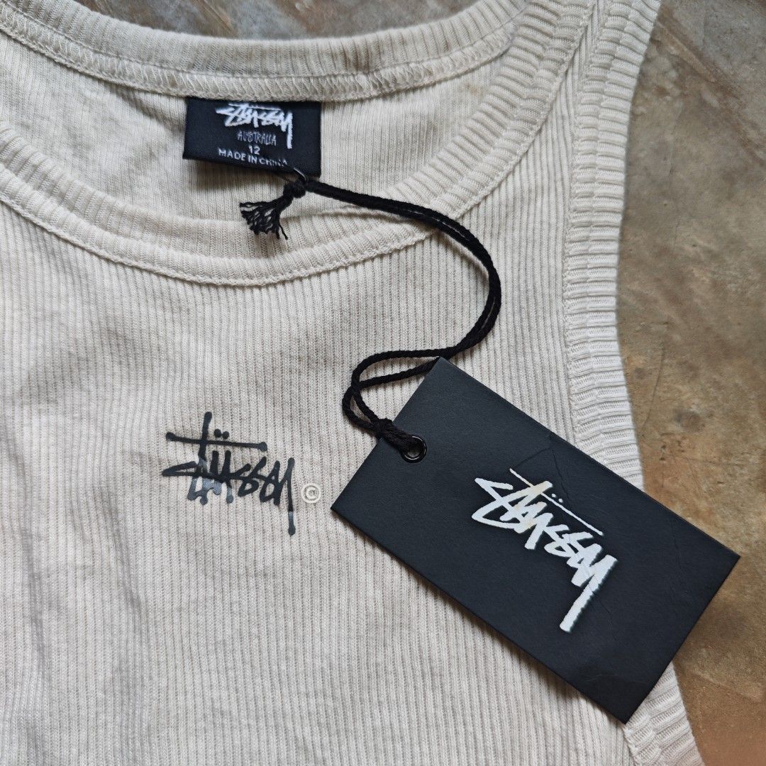 Stussy (Category: Sleeveless) located in Ipil. Submitted by ajthriftfinds (Listing ID 1464637758, Image 3). Description: - W: 13 (stretchy) - L: 20 - Brand new - Flawless - Color: Beige - Size: 12 - Features classic Stussy logo embroidered on chest - Brand new with original tags attached - Material: 100% Cotton - Made in China - Perfect staple piece for any outfit.