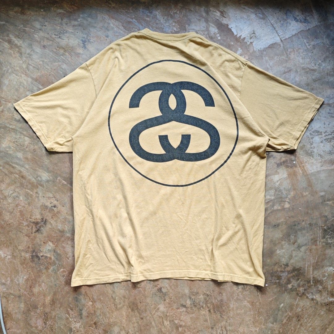 Stussy Big Link Tee 21SS (Category: Tshirts & Polo Shirts ) located in Ipil. Submitted by ajthriftfinds (Listing ID 1464637473, Image 1). Description: - Classic Stussy T-shirt - Color: Mustard Yellow - Size: Tagged XL - Design: Iconic Stussy logo on front, large circular logo on back - Material: 100% Cotton - Perfect for everyday wear.