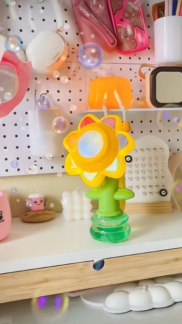 Sunflower Bubble Machine Toy with light (Category: Kids Toys) located in Taguig. Submitted by apzdeclutter (Listing ID 1464738432, Image 1). Description: - Vibrant yellow sunflower design with a green stem base - Multi-colored petals surrounding the center vent - Battery-operated (compartment located at the back) - Creates lots of bubbles effortlessly - Perfect as a fun desk toy, party accessory, or outdoor play item.