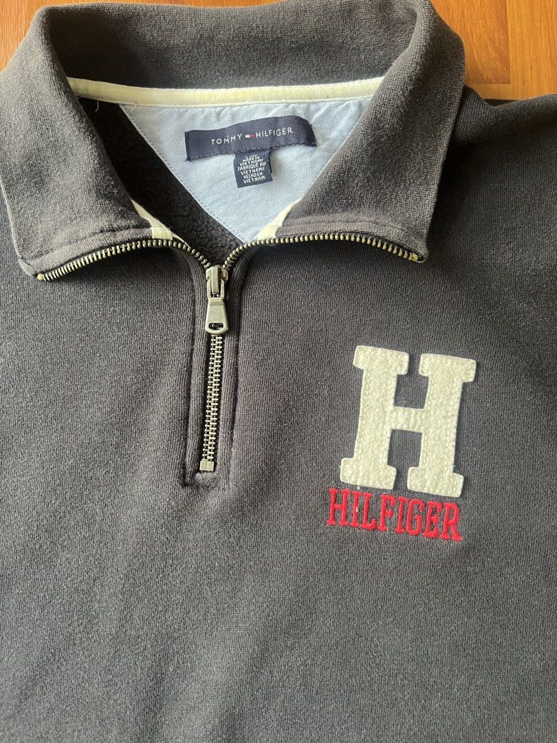 Tommy Hilfiger Big Logo "H" Quarter-Zip Pullover Sweatshirt (Category: Coats, Jackets and Outerwear) located in Lipa City. Submitted by alexcollectionco (Listing ID 1464723789, Image 3). Description: Classic navy Tommy Hilfiger 1/4 zip fleece pullover. Features a large embroidered “H” patch with red Hilfiger spellout on the chest, small signature flag logo tab near the bottom cuff, heavy metal zipper hardware, and a comfortable ribbed hem and cuf