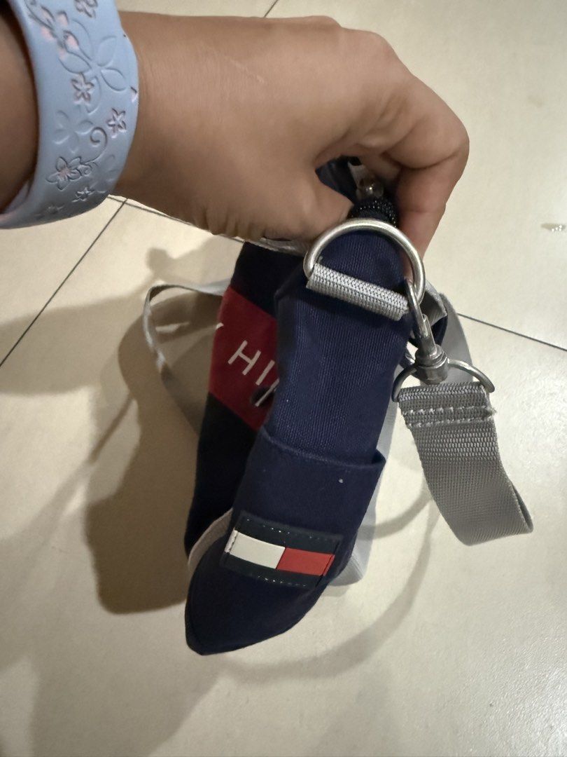 Tommy Hilfiger Navy Blue Mini Duffel Bag (Category: Cross-body Bags) located in Manila. Submitted by metrosen (Listing ID 1464582703, Image 3). Description: - Navy blue mini duffel bag by Tommy Hilfiger - Iconic red and white logo stripe on the front - Main zippered compartment - Interior pocket for organization - Detachable and adjustable shoulder strap - Two small top handles for easy carrying - Ideal for quick getaways or gym essentials.