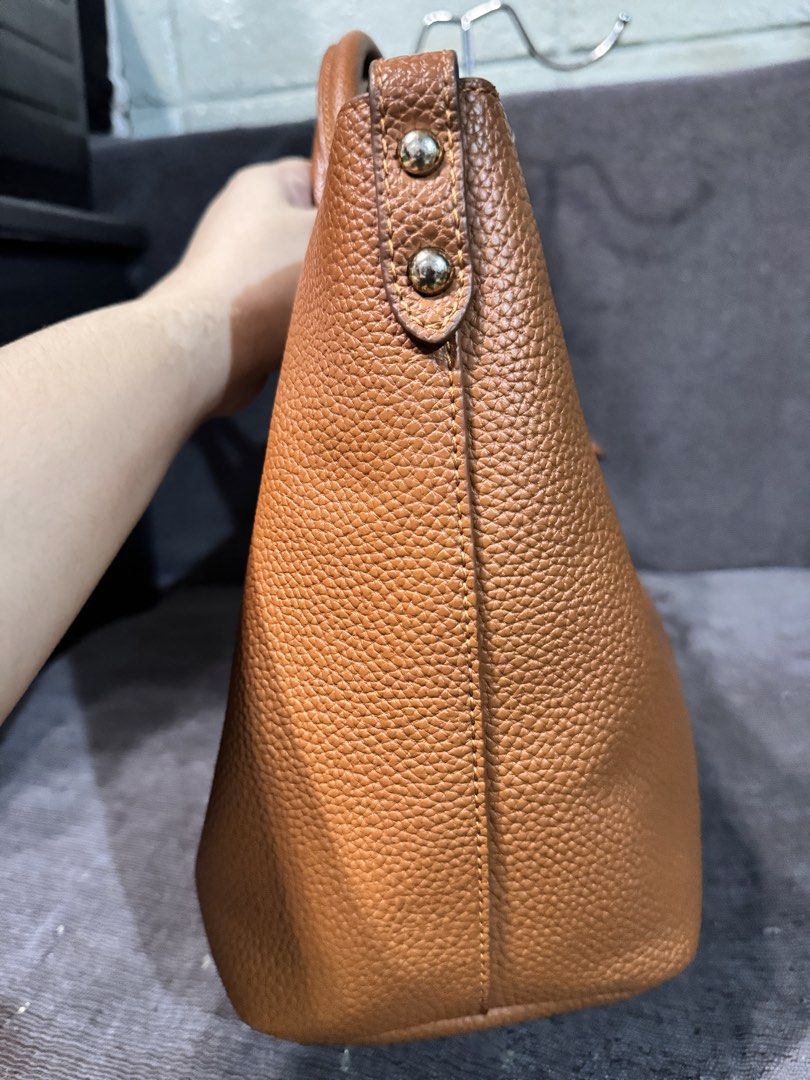 Tory Burch Brown Leather Tote Bag (Category: Tote Bags) located in Manila. Submitted by dearpinkcollections (Listing ID 1464681200, Image 3). Description: - Stylish brown pebbled leather tote bag - Elegant gold hardware details - Comfortable top handles with buckle accents - Interior zip pocket and central compartment - Ample space for all your essentials - Ideal for everyday wear and errands - minimal issue in handle.