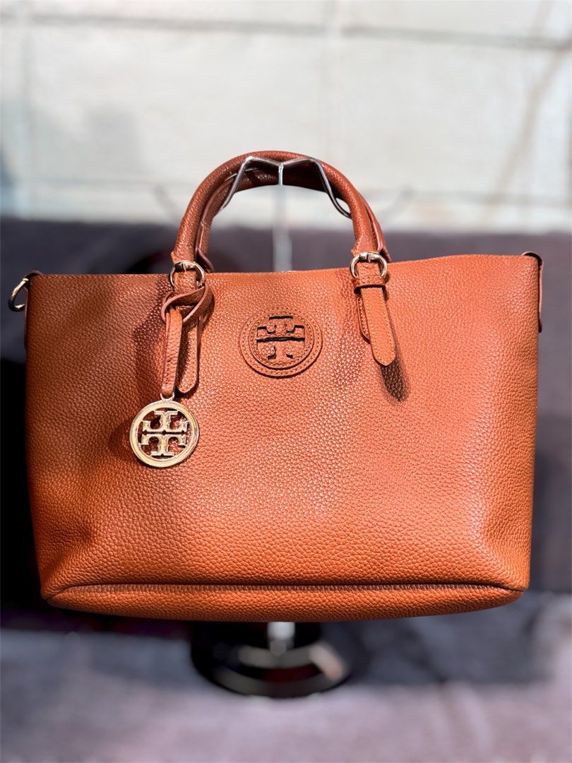 Tory Burch Brown Leather Tote Bag (Category: Tote Bags) located in Manila. Submitted by dearpinkcollections (Listing ID 1464681200, Image 1). Description: - Stylish brown pebbled leather tote bag - Elegant gold hardware details - Comfortable top handles with buckle accents - Interior zip pocket and central compartment - Ample space for all your essentials - Ideal for everyday wear and errands - minimal issue in handle.