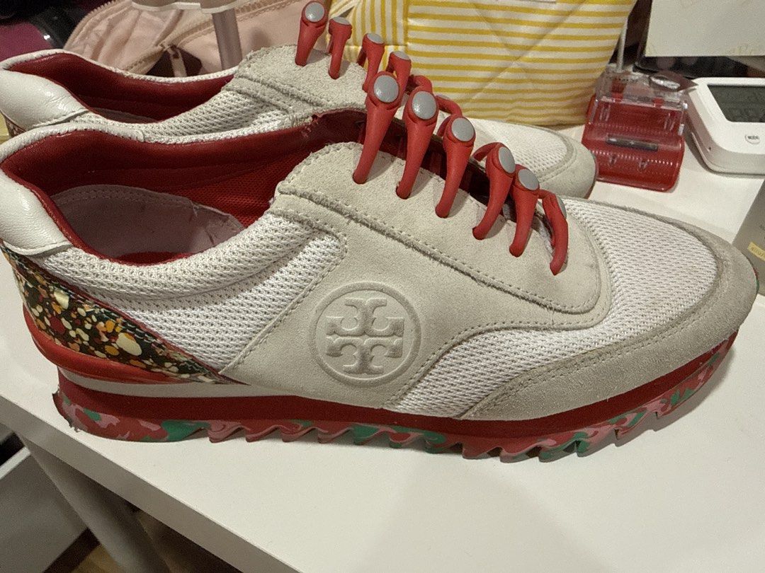 Tory Burch White and Red Sneakers (Category: Sneakers) located in Makati City. Submitted by brightbear.716194 (Listing ID 1464734372, Image 1). Description: - Brand: Tory Burch - Material: White mesh and suede upper - Colorway: White with striking red lining, ridged outsole, and heel accents - Closure: Convenient red elastic toggle laces for an easy slip-on fit - Design: Unique patterned heel counter and embossed side logo - Style: Comfortable ca