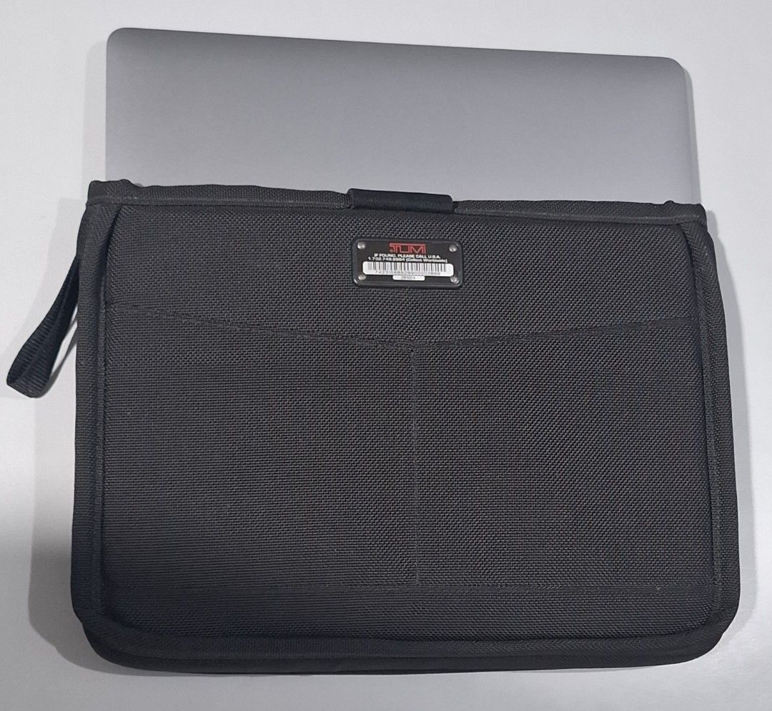 Tumi Black Nylon Laptop Sleeve (Category: Laptop Bags & Sleeves) located in Makati City. Submitted by decluttermp (Listing ID 1464606311, Image 1). Description: - Brand: TUMI - Color: Black - Material: Nylon - Dimensions: L - in x W - x D - - Features: Front pocket, strap closure - Compatibility: Fits 13 inch MacBook Air - Function: Protects your device - Design: Clean and simple.
