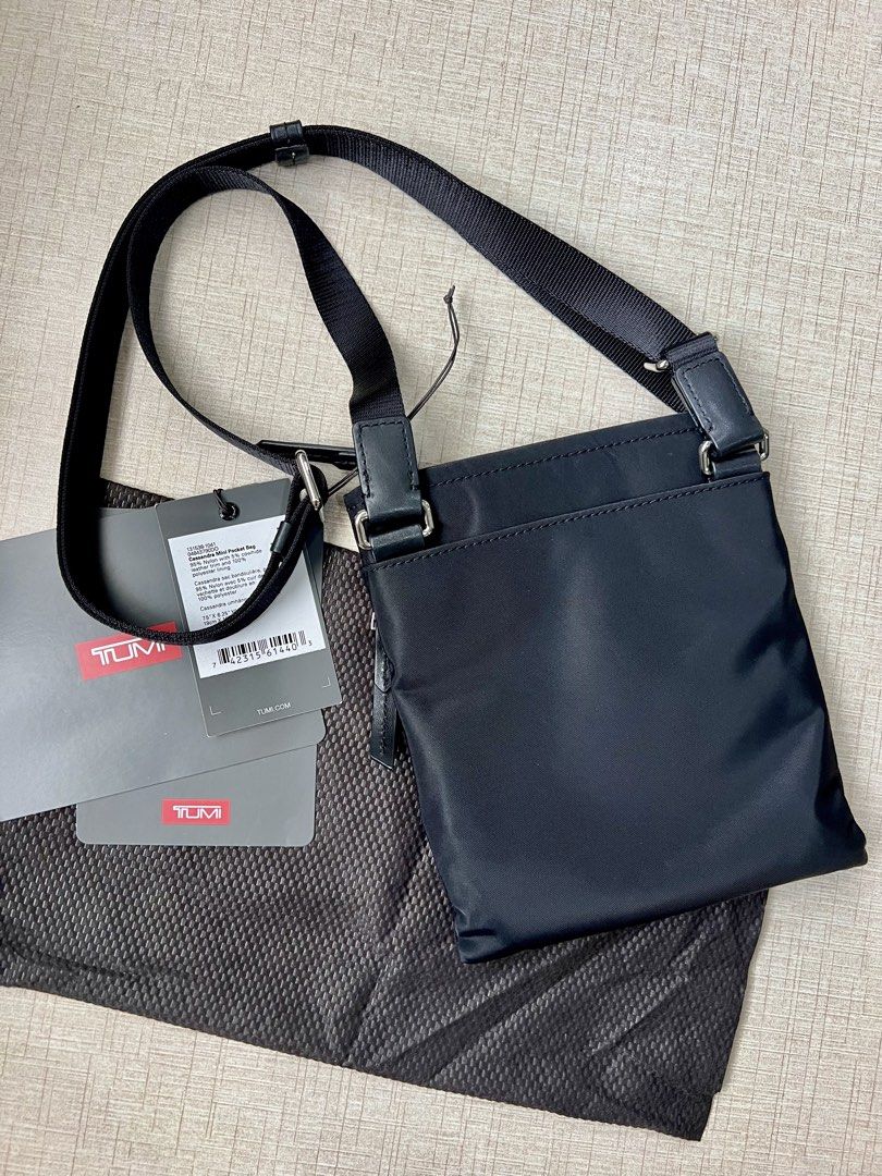 Tumi Cassandra Mini Pocket Bag (Category: Cross-body Bags) located in Quezon City. Submitted by fromkimwithless (Listing ID 1464745393, Image 2). Description: - Flaw: has lipstick stain inside - Color: Black Lightweight Nylon with Black Leather Trim - Fit: Fits passport, large smartphone, cardholder, keys, and daily travel essentials - Includes: dust pouch, original hangtag.