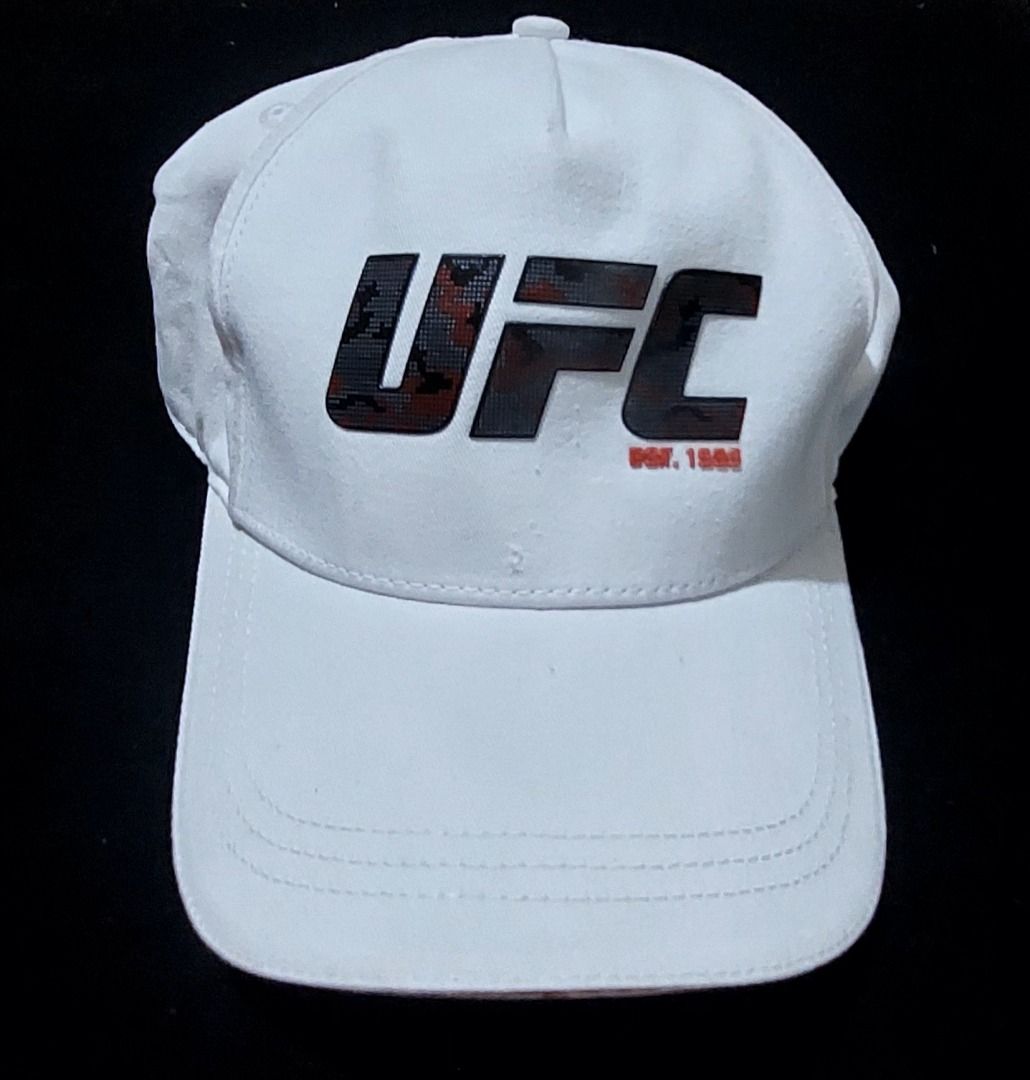 UFC White Cap Adjustable Snapback (Category: Caps & Hats) located in Legazpi City. Submitted by street_uniform (Listing ID 1464740375, Image 1). Description: - 100% authentic UFC merchandise in clean white cotton twill - Features a bold digital camouflage logo with striking red branding details - Adjustable plastic snapback closure for a comfortable, custom fit - Premium interior finish with branded red UFC seam tape - Condition: Brand new / Exce
